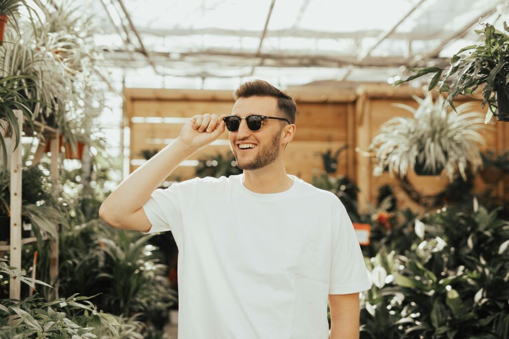 smiling man in sunglasses in greenhouse