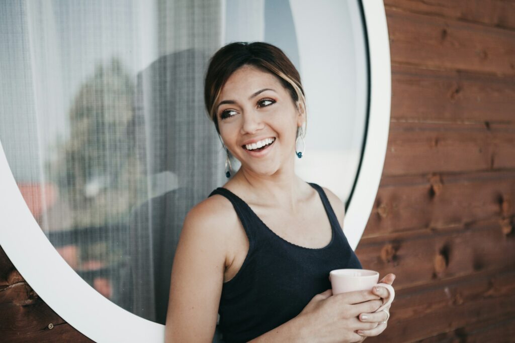 smiling woman with coffee on porch