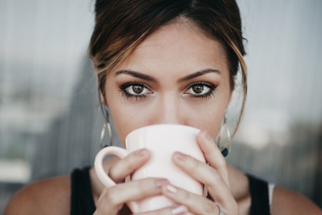 woman eyes coffee cup