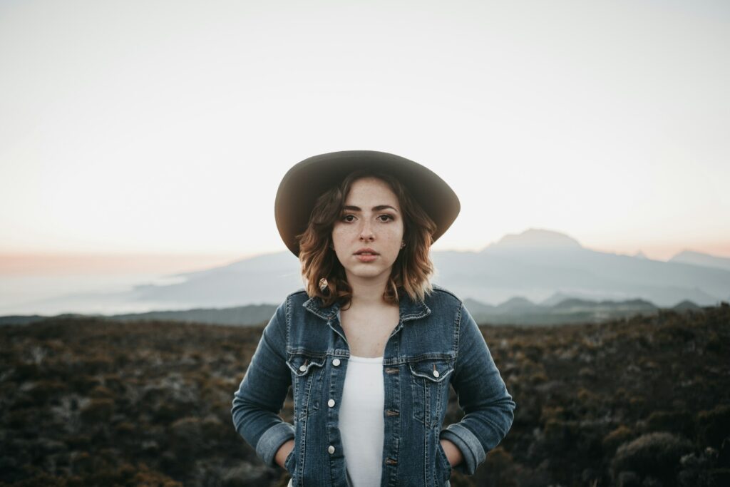 woman in hat and hands in jean jacket pocket