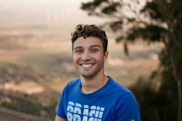 smiling man in blue t-shirt outside