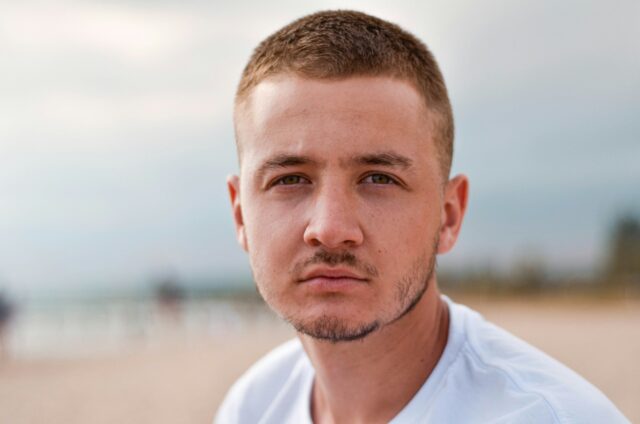 serious guy standing on beach