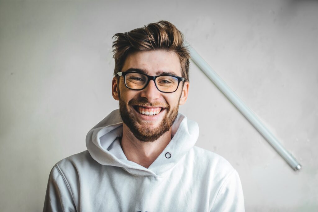 smiling man laughing in white hoodie
