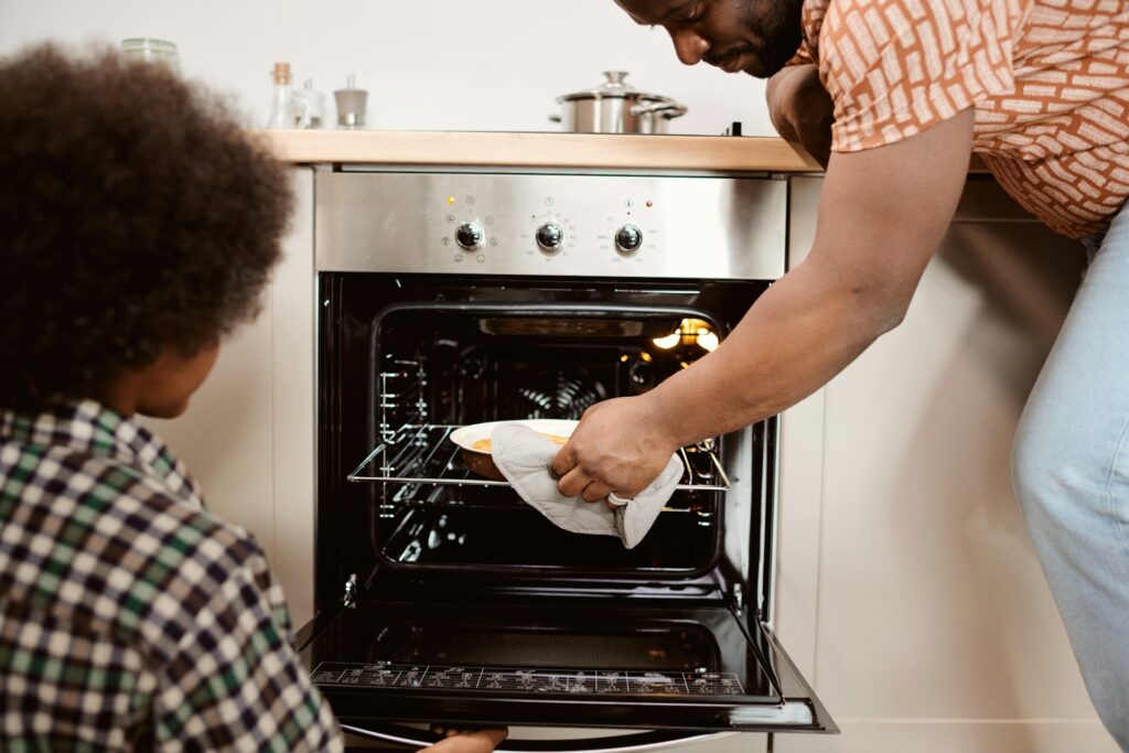 family taking food out of oven