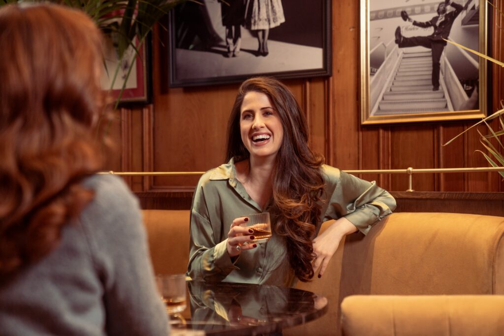 woman talking to her friend with cocktail